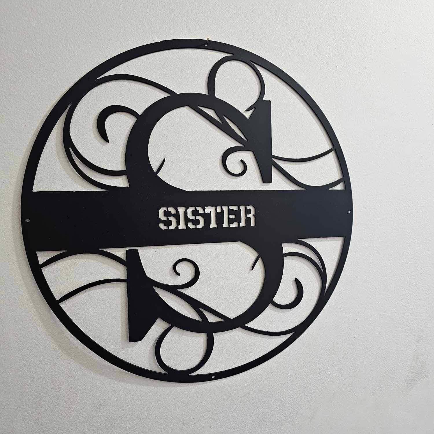 A round black steel monogram sign with the word Sister