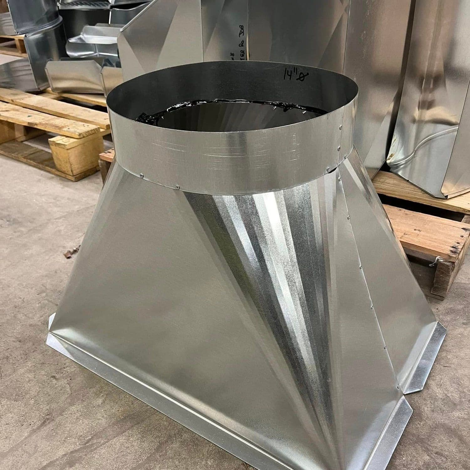A galvanized round-to-square duct transition