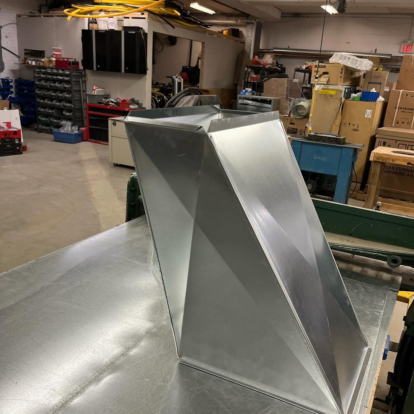 A galvanized sheet metal duct transition on the shop bench