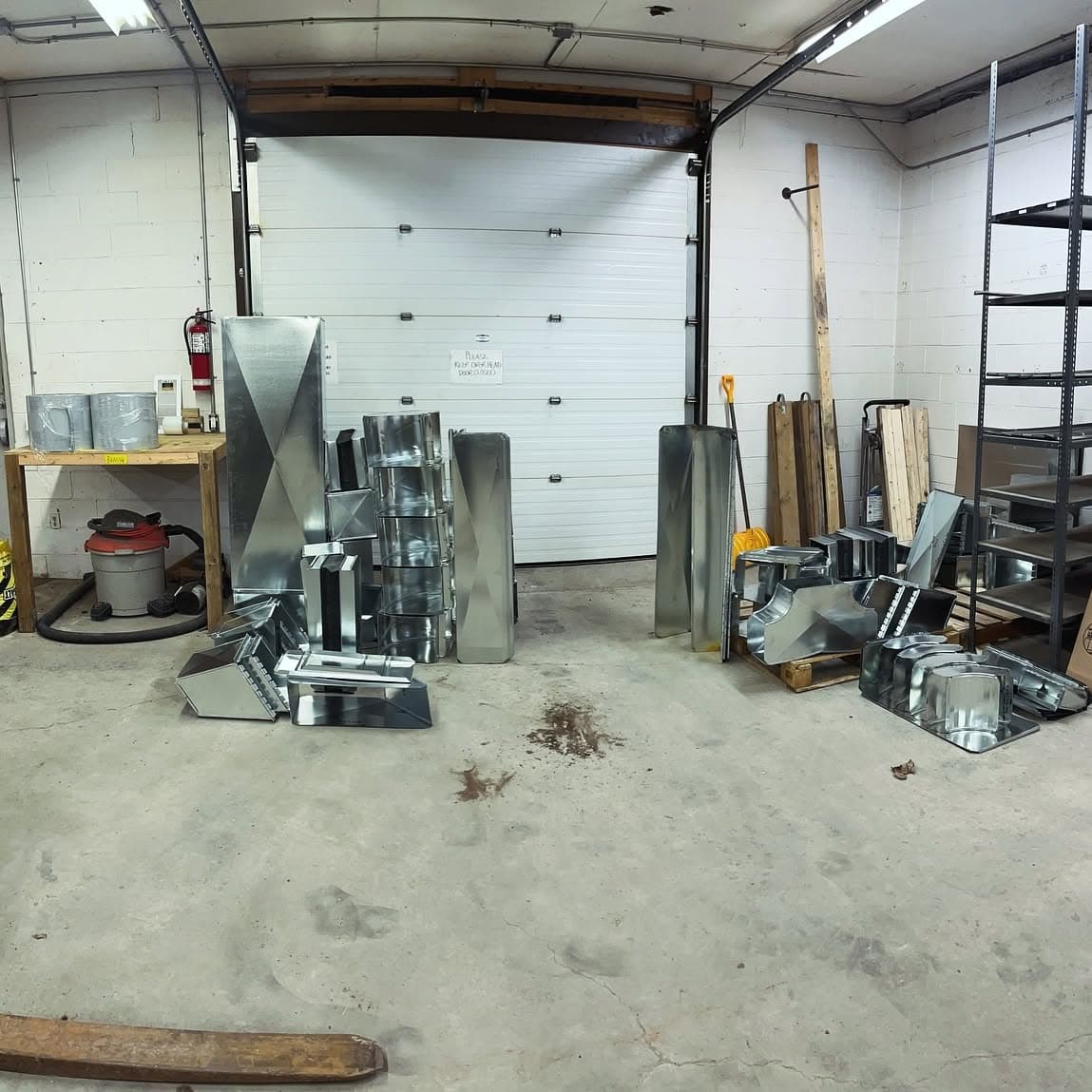 Inside the Pollard Custom Metal shop, with finished fittings by the bay door